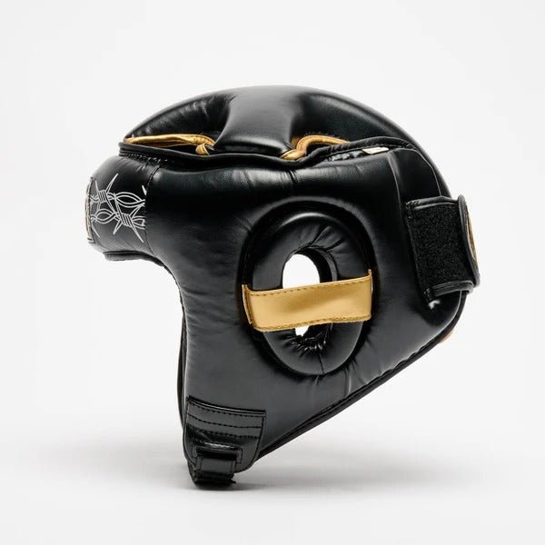 Perfil del casco LEONE x IUTER que muestra la protección auditiva acolchada y los acabados dorados.