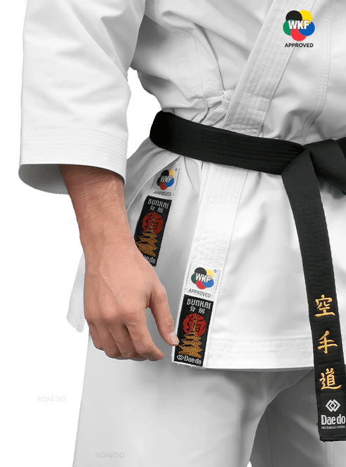 Detail schvalovacího štítku WKF Approved a logo Daedo vyšité na karate gi.