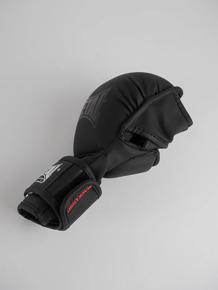 Vista lateral de los guantes de boxeo de metal MMA sparring, centrándose en el pulgar reforzado y el cierre