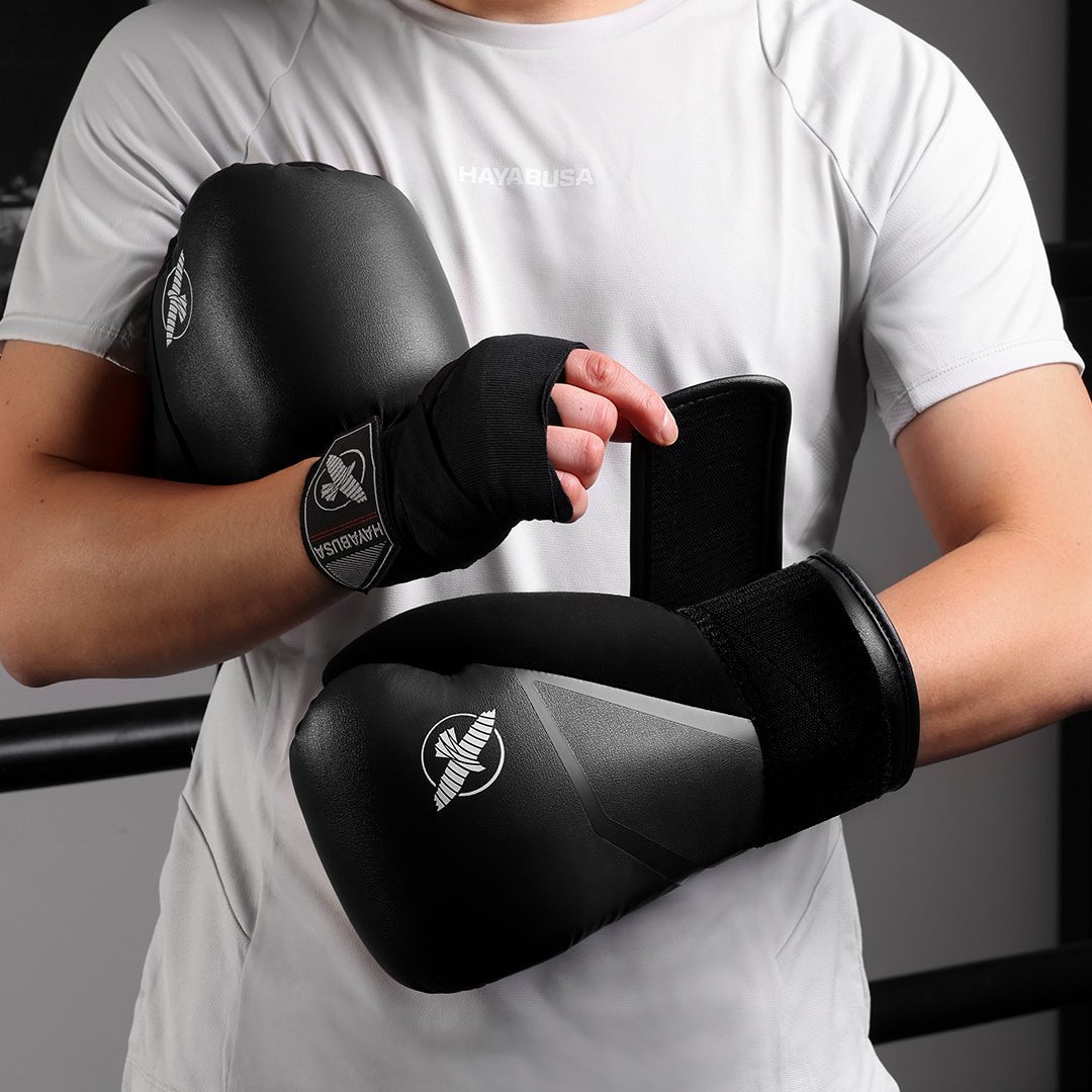 Foto das luvas de boxe pretas Hayabusa E1 usadas por um lutador
