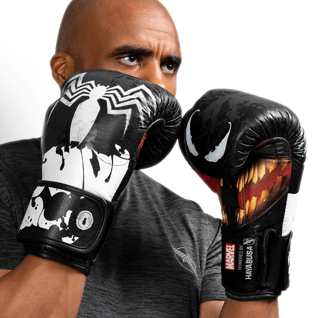 Atleta usando luvas Hayabusa Marvel Venom pretas e brancas em posição de ataque