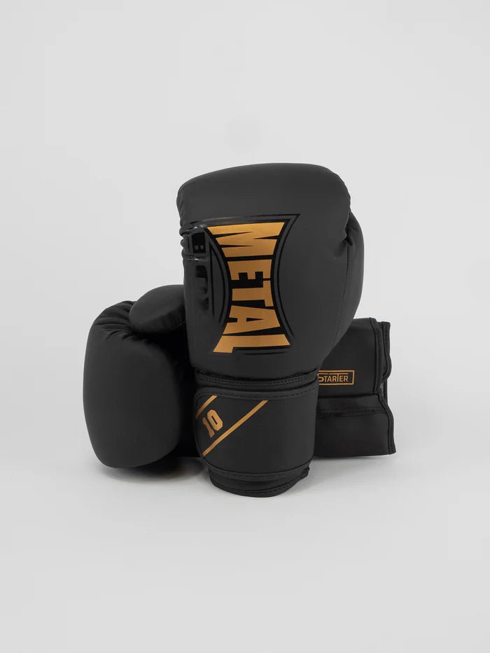 Vista frontal das luvas pretas e douradas Metal Boxing Starter, estética profissional júnior