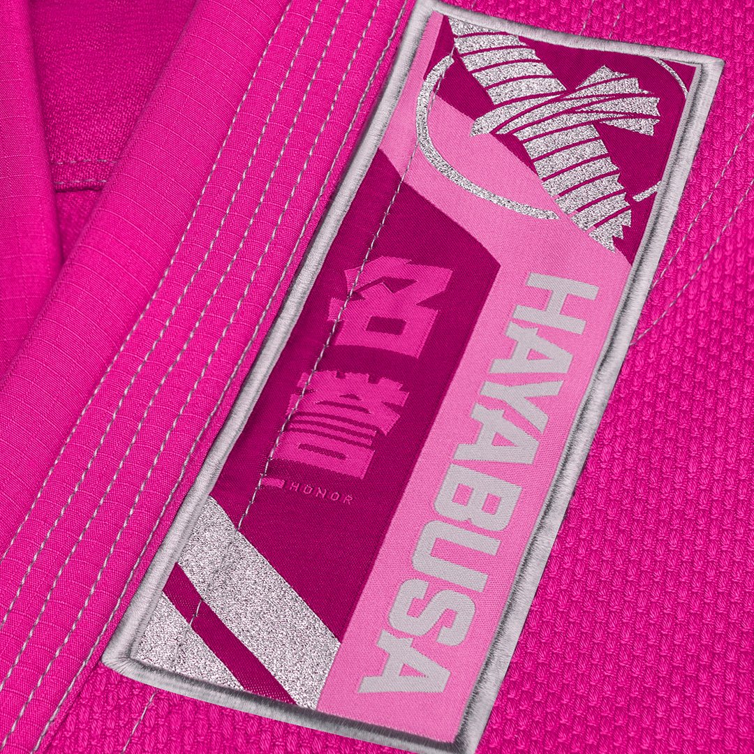 Primer plano de los logotipos y escritos bordados en la variante rosa del Hayabusa Gi.