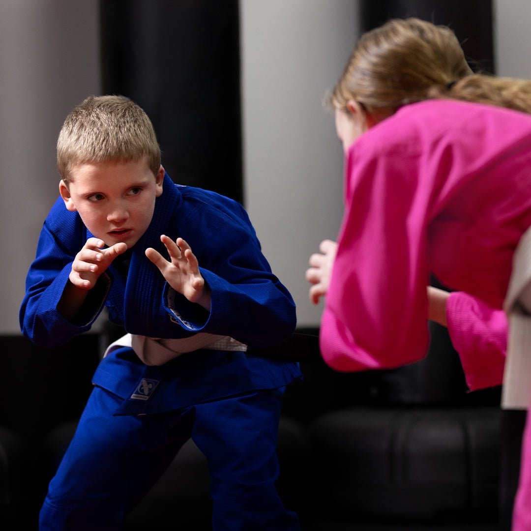 Niño en acción sobre el tatami con el kimono azul Hayabusa Essential Kids