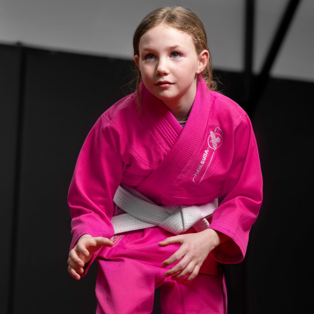 Niña durante una sesión de Jiu Jitsu luciendo el kimono rosa Hayabusa Essential