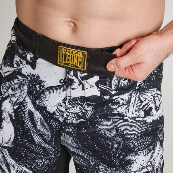 Gros plan sur le panneau de fermeture avant du short LEONE x IUTER, montrant le cordon de serrage interne et le patch en fil doré sur la ceinture