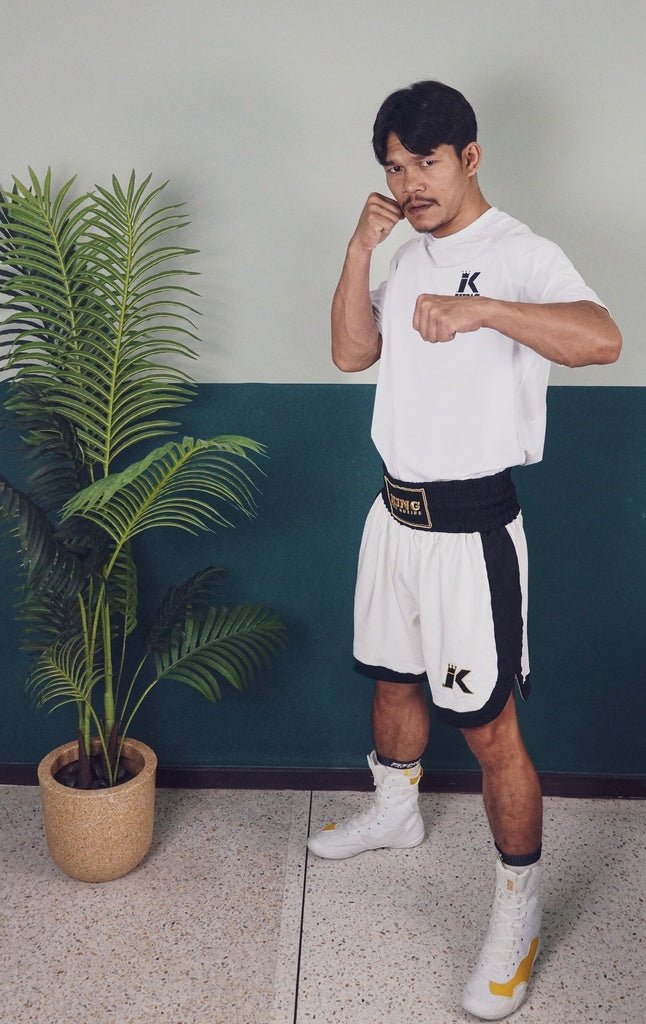 Le boxeur porte le short blanc K King Apex Pro montrant la coupe professionnelle sur le ring.