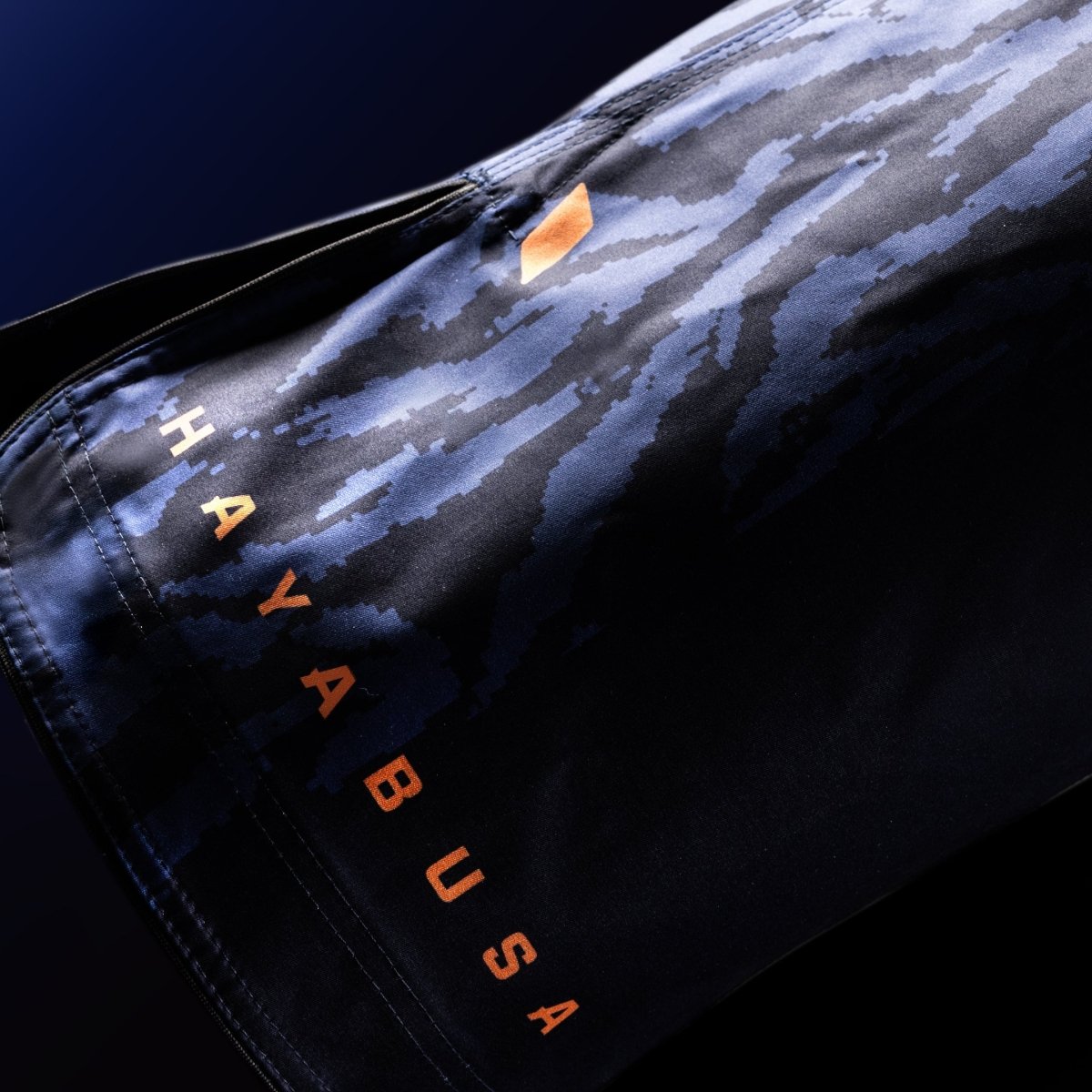 Primer plano de las letras oficiales de Hayabusa impresas en la pernera de los pantalones cortos de combate azules.