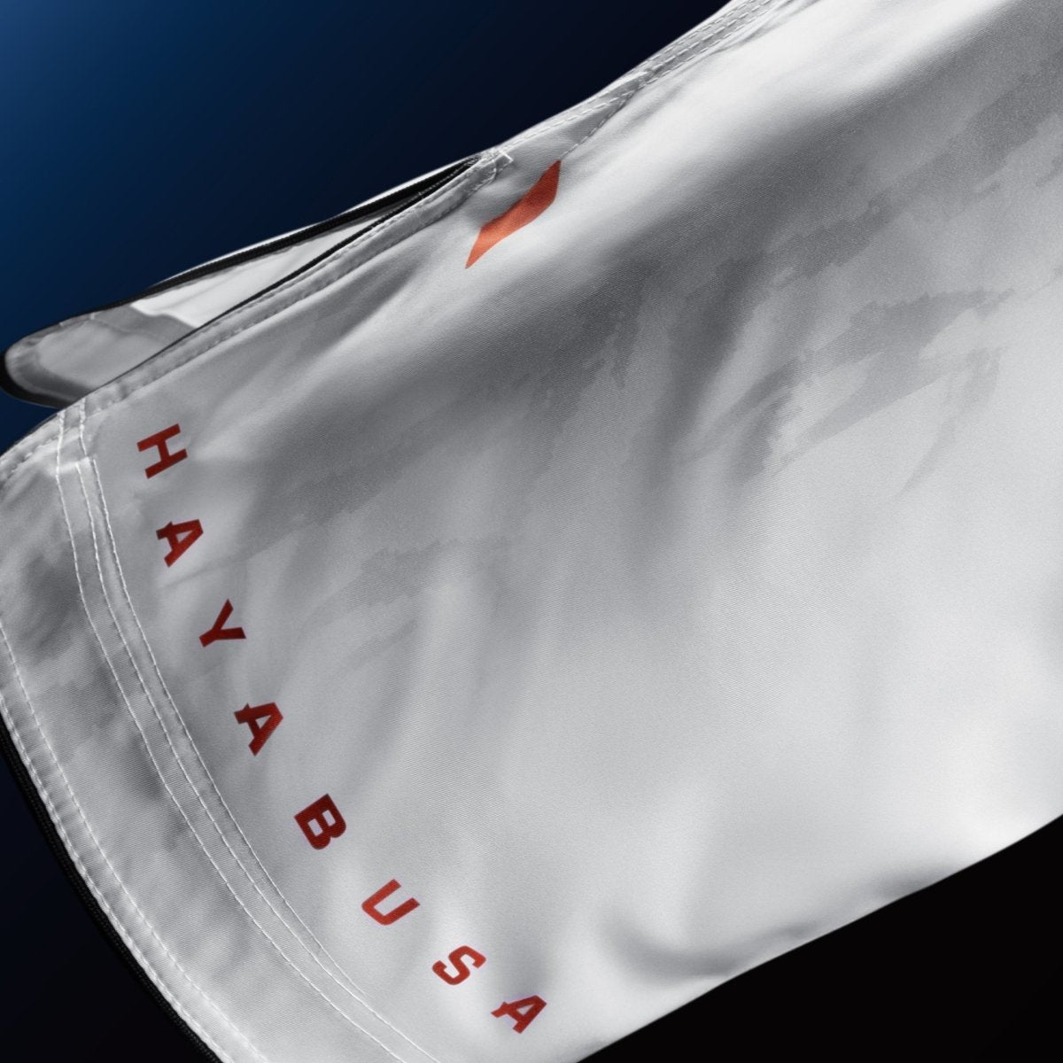 Detalle de la escritura de la marca Hayabusa en la pernera del short blanco para BJJ y MMA
