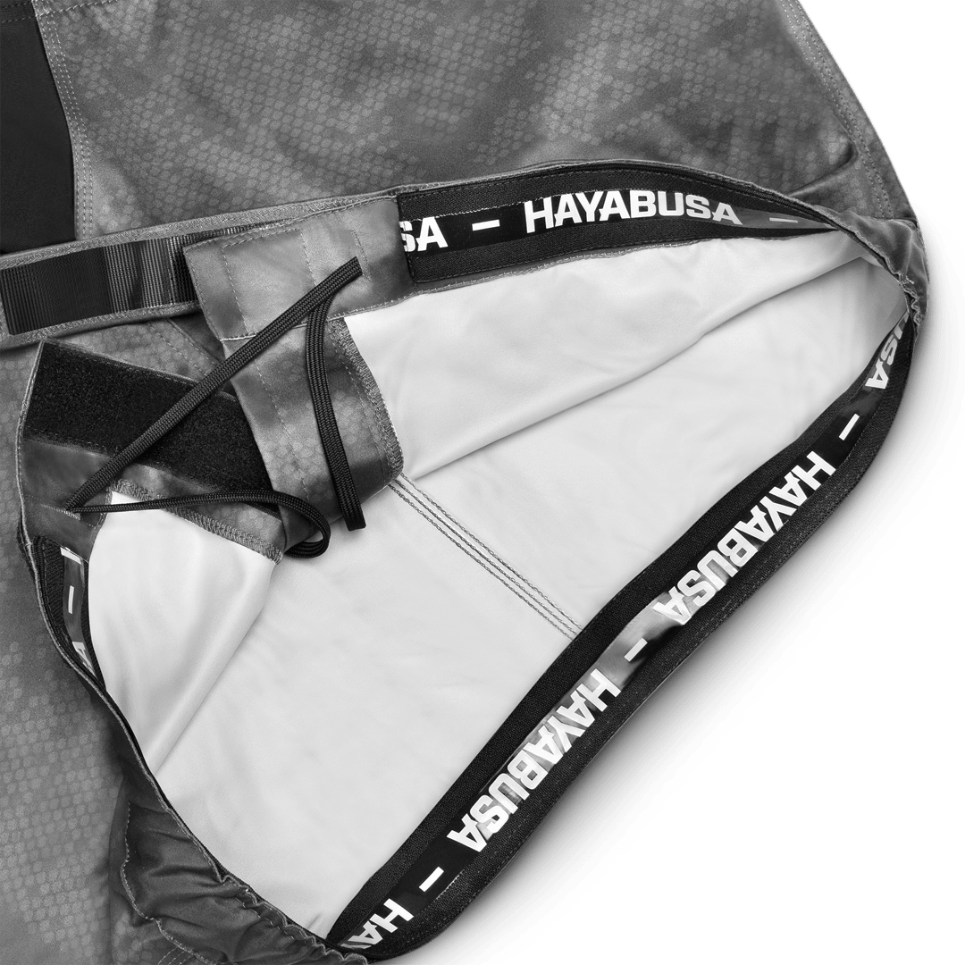 Primer plano del sistema de cierre y agarre de silicona dentro de la cinturilla del pantalón corto gris.