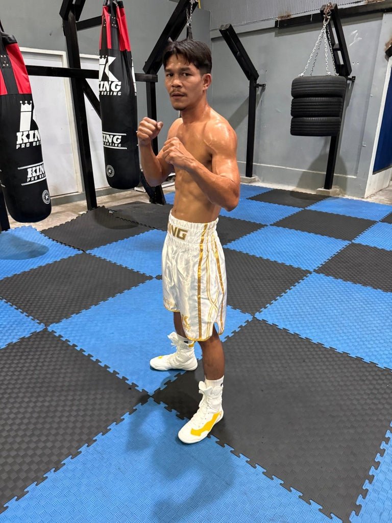 Le boxeur professionnel porte le short blanc KPB XK, montrant le contraste des logos et la respirabilité du tissu