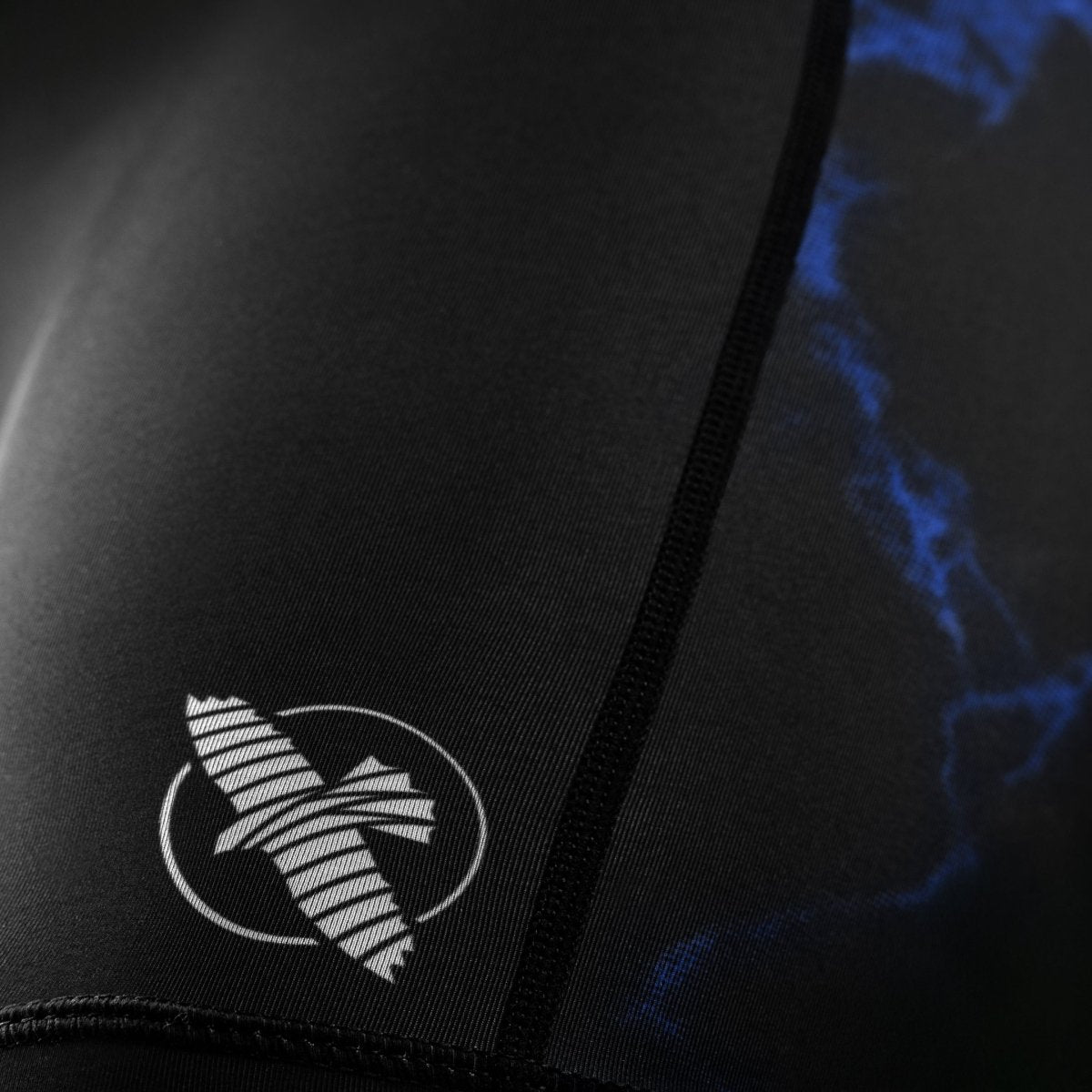 Detalle de los gráficos de UFC impresos en la pernera del pantalón corto de mujer Vale Tudo negro y azul