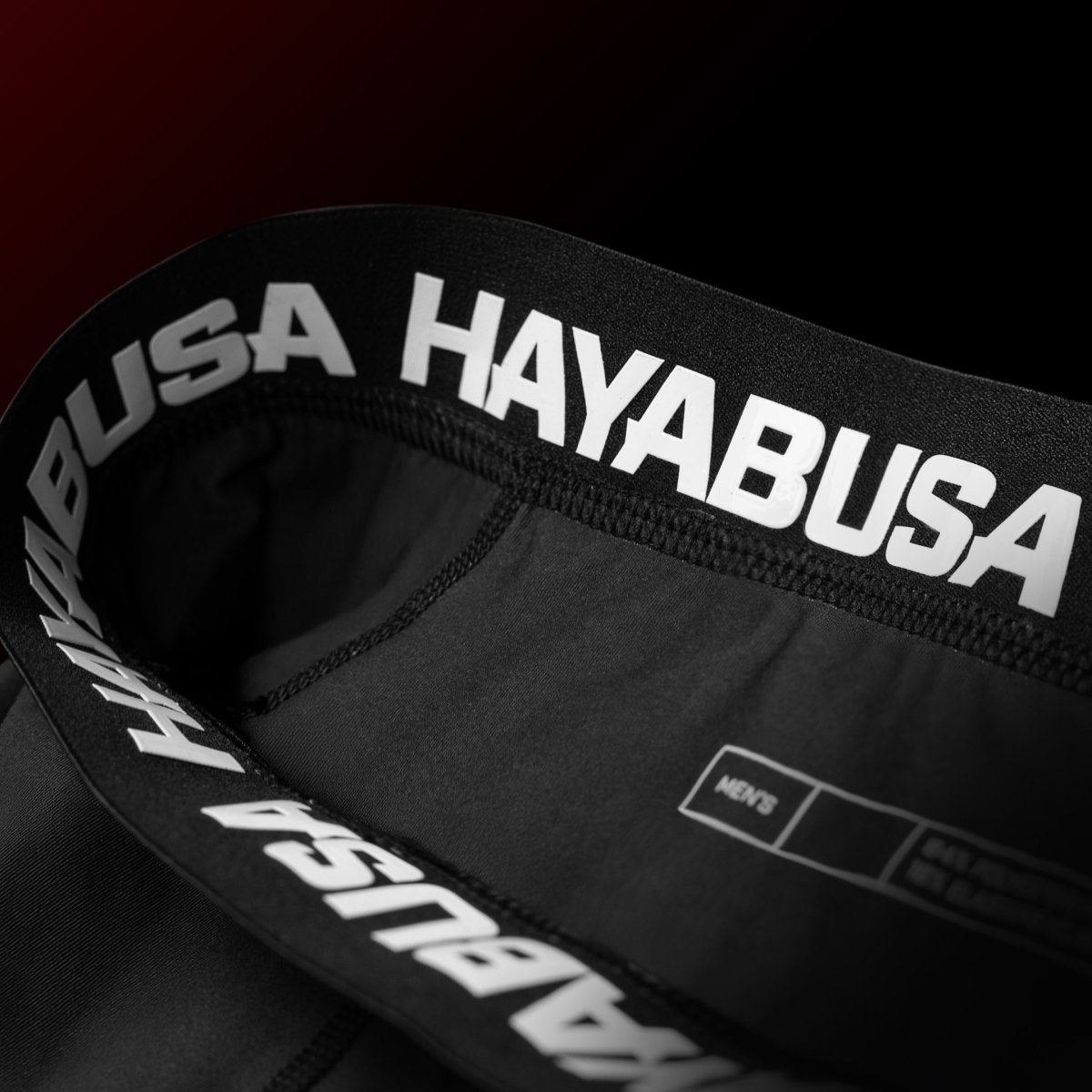 Detalle de la cinturilla con agarre de silicona del pantalón corto oficial de BJJ de UFC rojo y negro.