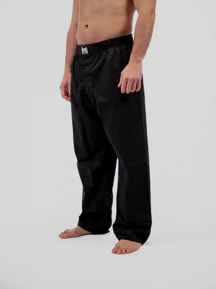 Detalle frontal de pantalones de boxeo Krav Maga Metal negros, centrados en la textura antidesgarros.