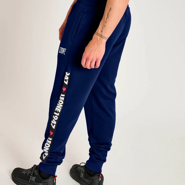 Vista trasera de pantalones deportivos azules con detalle de rayas gráficas.