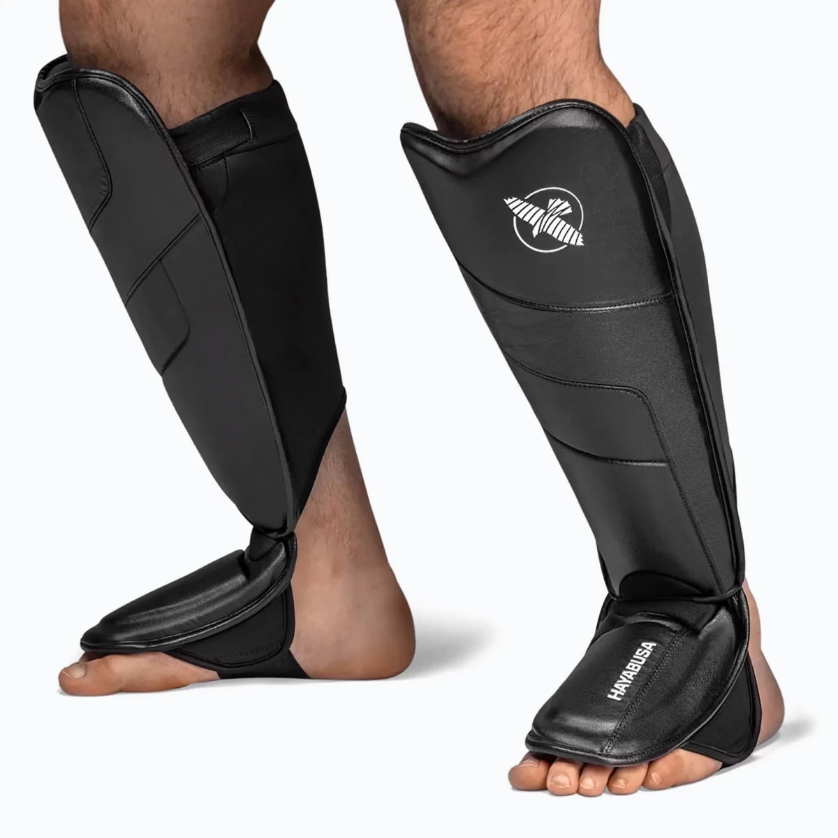 Detalle de la protección multicapa en la tibia de las espinilleras T3 en piel sintética Vylar de color negro.