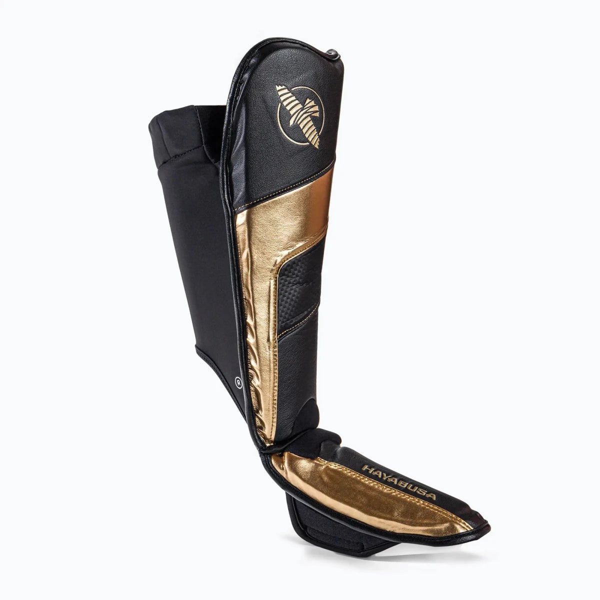 Detalle de los logos dorados y acabados premium de las espinilleras Hayabusa T3 Black Gold.