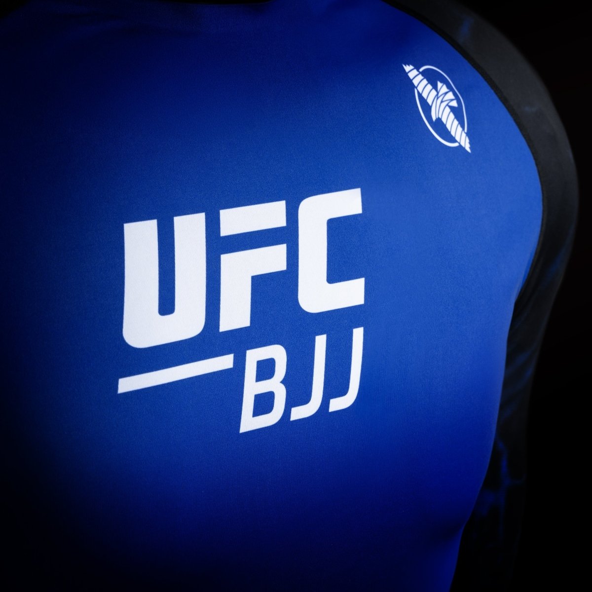 Detalle del logo de UFC en la lycra de competición negra y azul, detalle del tejido de alta resistencia