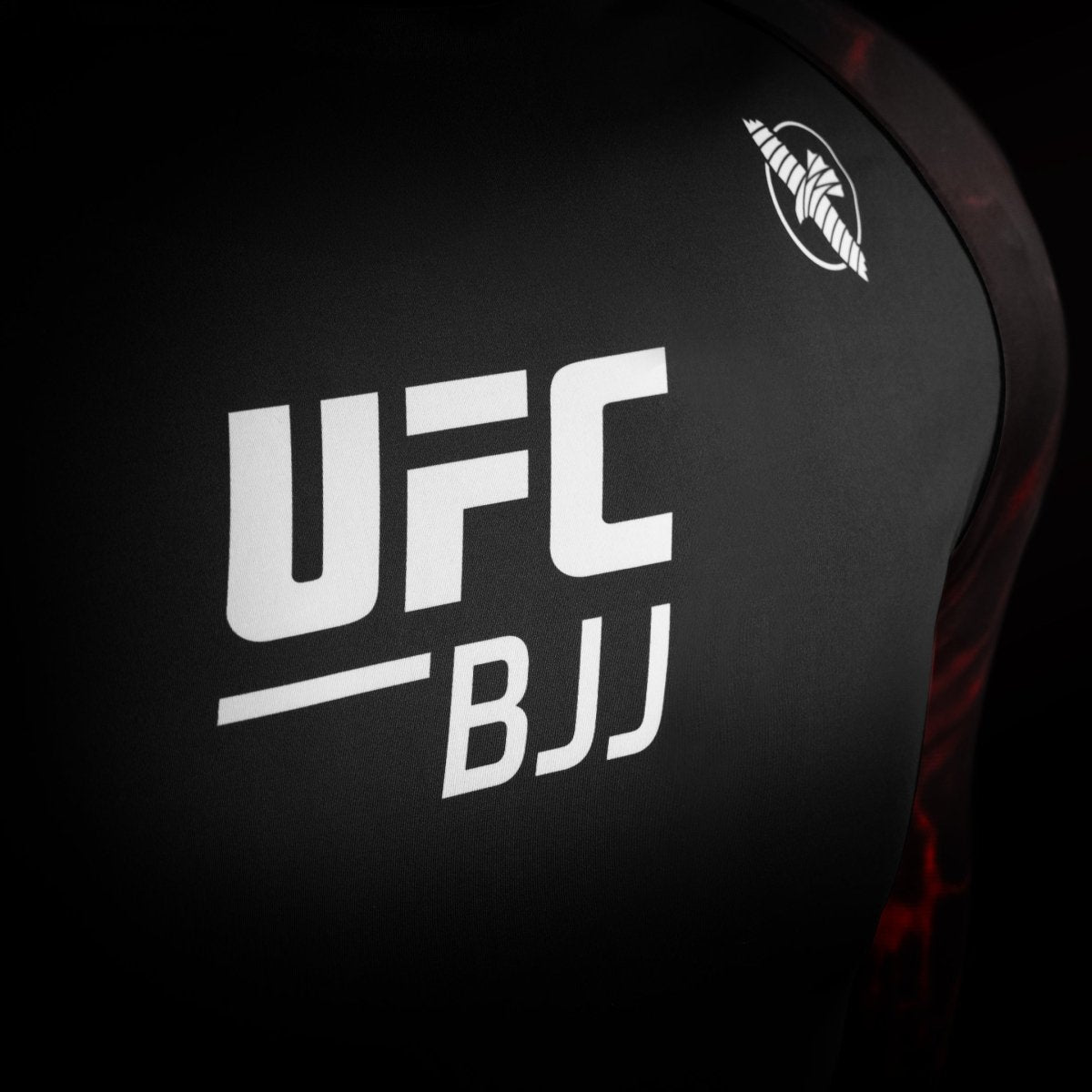 Detalle del logotipo oficial de UFC en la lycra de competición negra y roja.