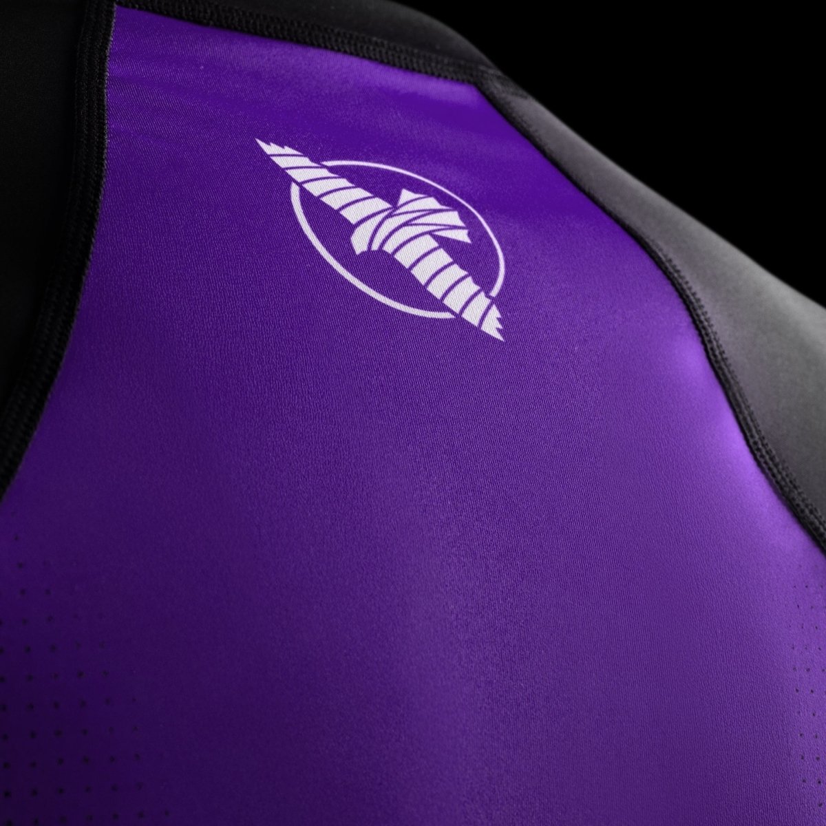 Detalle de la marca Hayabusa sublimada en el pecho de la licra de competición morada.